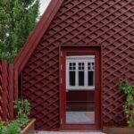 Casa de madera roja donde la arquitectura se abre a la naturaleza