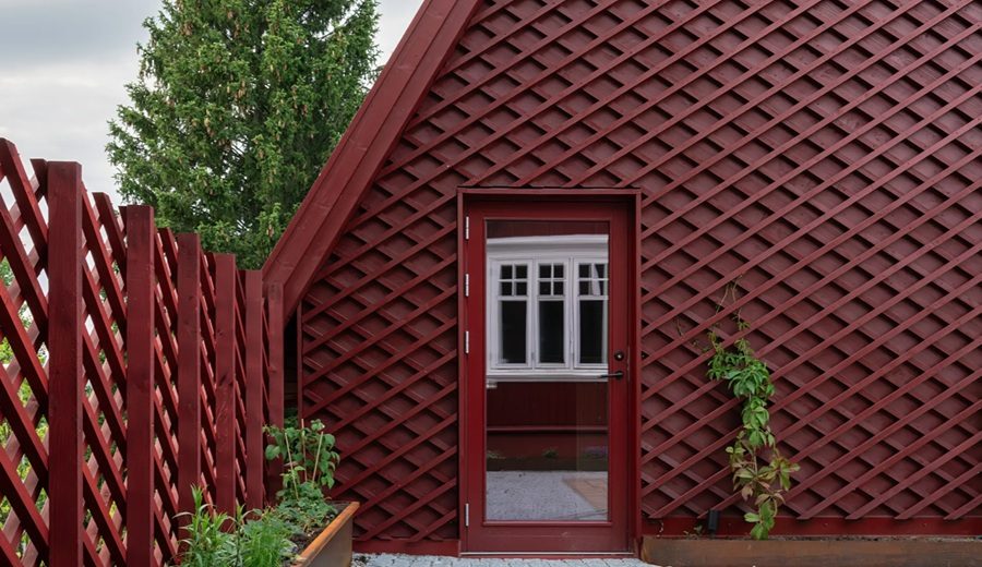 Casa de madera roja donde la arquitectura se abre a la naturaleza